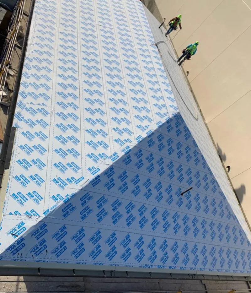 Professional roofers installing underlayment on a metal roof in Pleasant Valley